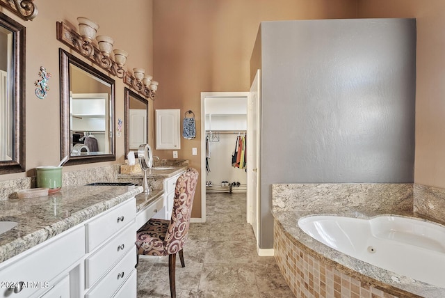 bathroom with vanity and a relaxing tiled tub