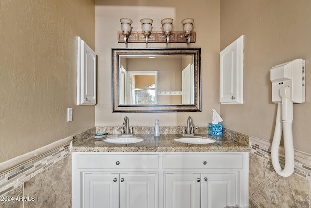 bathroom with vanity and tile walls