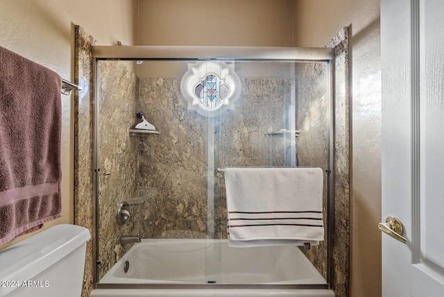 bathroom with combined bath / shower with glass door and toilet