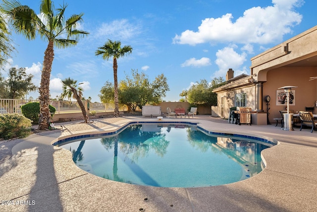 view of pool with area for grilling and a patio area