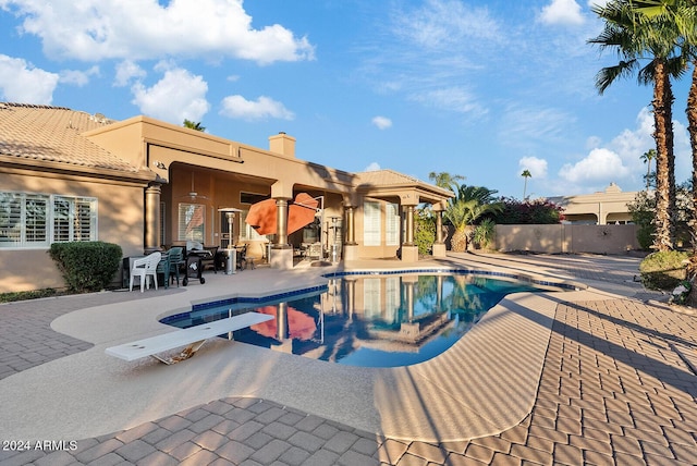 view of swimming pool with a diving board and a patio area