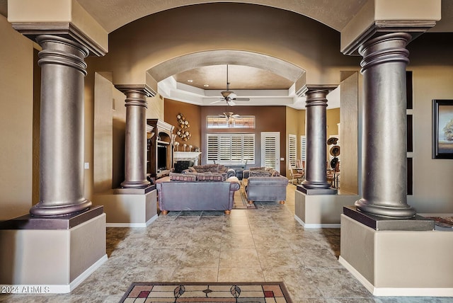 interior space featuring light tile patterned floors, a tray ceiling, and ceiling fan