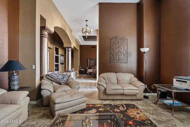 living room with ornate columns and a notable chandelier