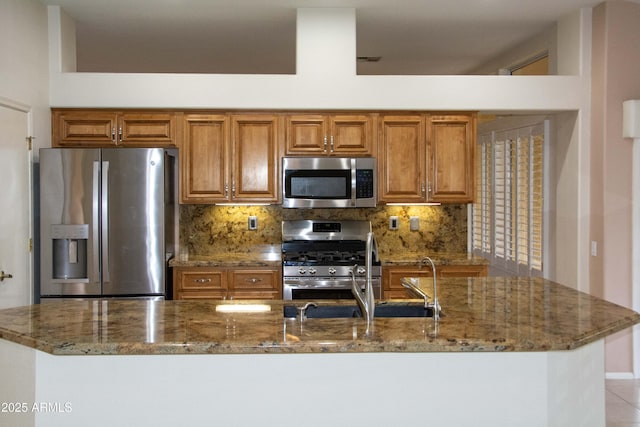 kitchen with stainless steel appliances, stone counters, and backsplash