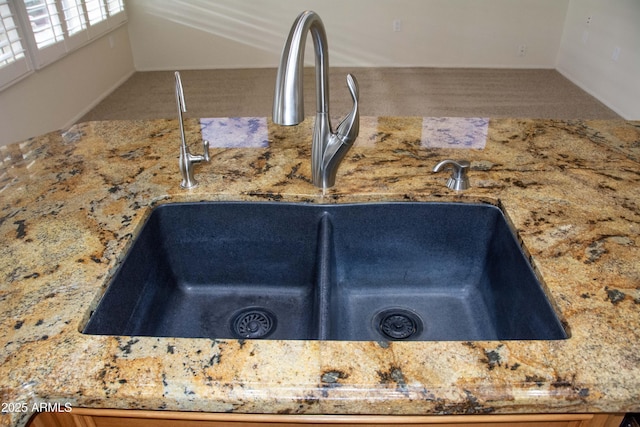 interior details featuring stone countertops and sink