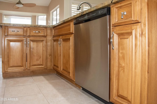 kitchen with dishwasher, light stone countertops, light tile patterned floors, and ceiling fan