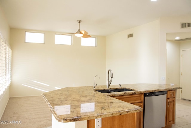 kitchen featuring sink, hanging light fixtures, a kitchen island with sink, stainless steel dishwasher, and light tile patterned floors