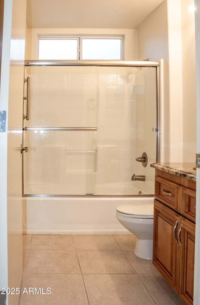 full bathroom with tile patterned flooring, vanity, shower / bath combination with glass door, and toilet