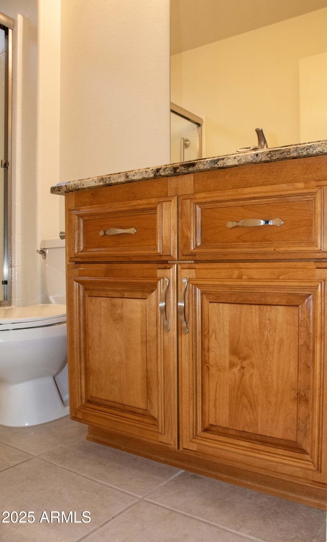 bathroom featuring walk in shower, tile patterned floors, and toilet