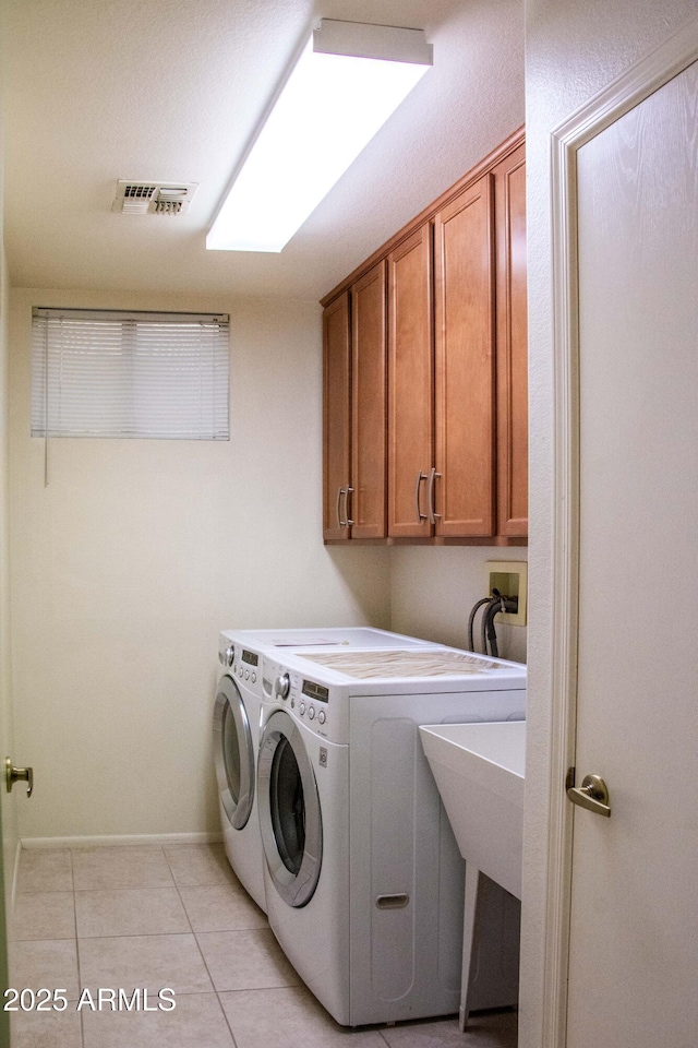 laundry room with cabinets, light tile patterned flooring, and independent washer and dryer