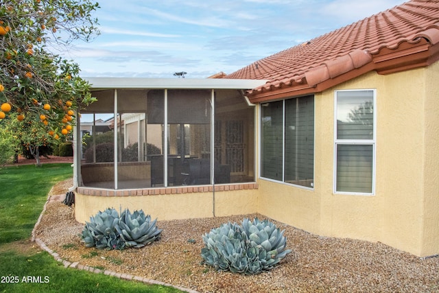 rear view of house featuring a sunroom