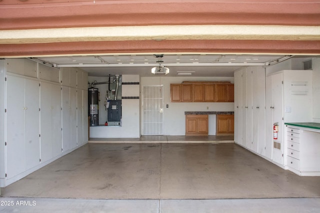 garage featuring water heater, a garage door opener, and heating unit