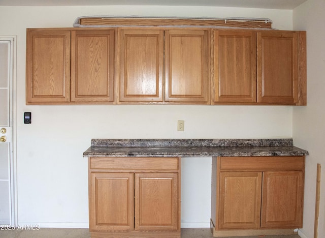 kitchen featuring built in desk and dark stone countertops