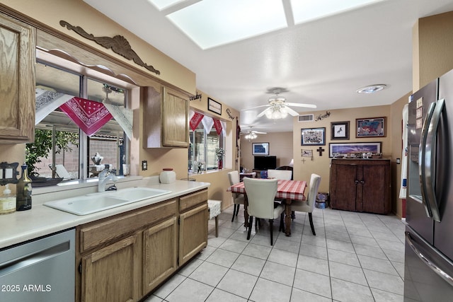 kitchen with light countertops, visible vents, freestanding refrigerator, a sink, and dishwasher