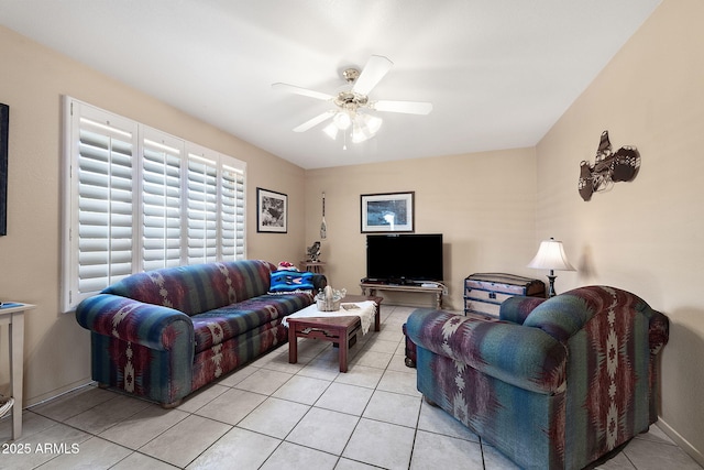 living area featuring ceiling fan, baseboards, and light tile patterned floors