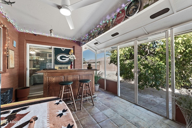 bar featuring a bar, a sunroom, and a ceiling fan