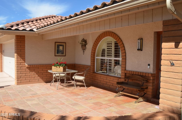 view of patio with outdoor dining area and an attached garage