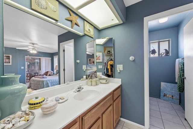 ensuite bathroom with ensuite bathroom, ceiling fan, vanity, and tile patterned floors