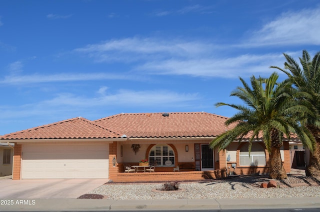 view of front of property with an attached garage, concrete driveway, and a tiled roof