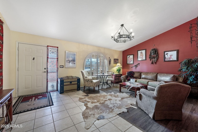 living room with lofted ceiling, light tile patterned floors, and an inviting chandelier