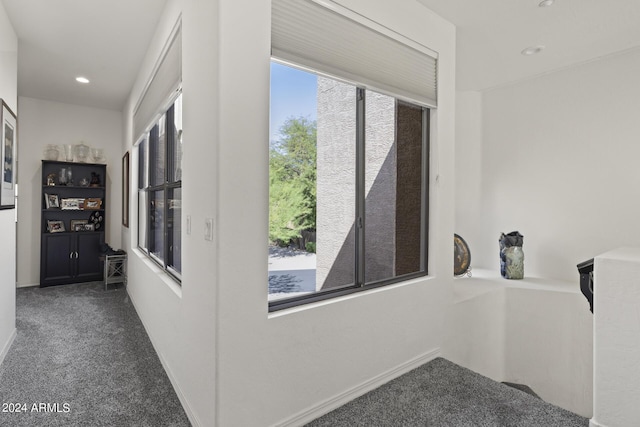 hall featuring dark colored carpet