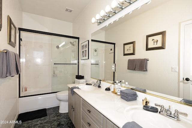 full bathroom featuring vanity, bath / shower combo with glass door, and toilet