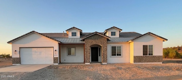 view of front facade with concrete driveway, brick siding, a garage, and metal roof