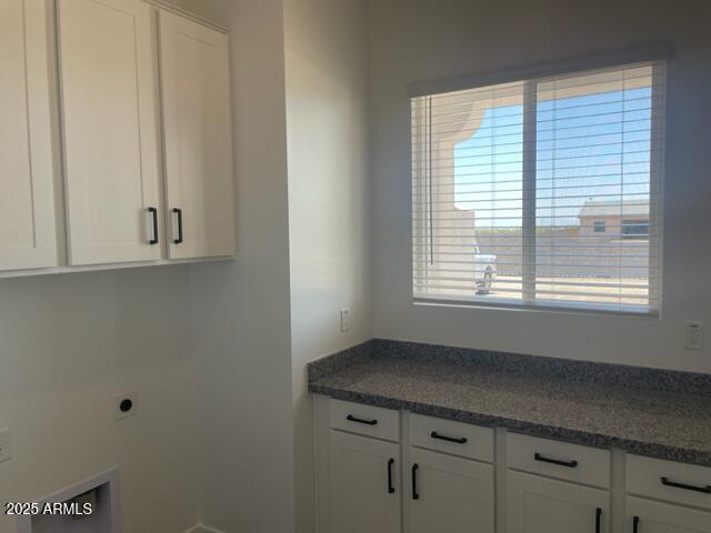 clothes washing area featuring cabinet space and hookup for an electric dryer