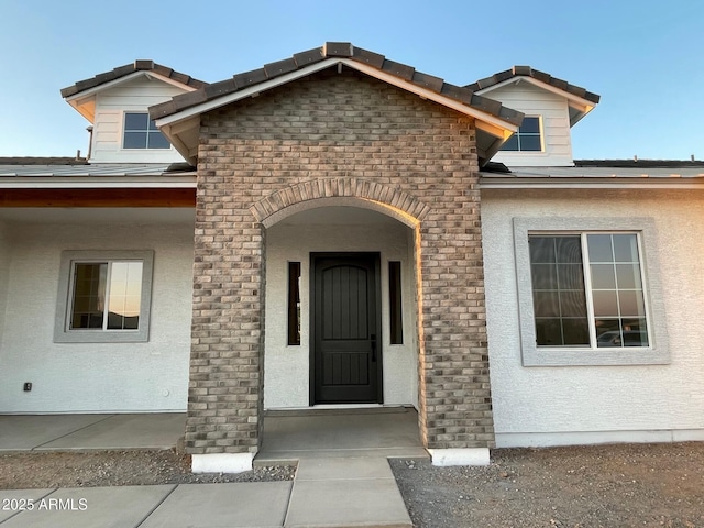 doorway to property featuring stucco siding