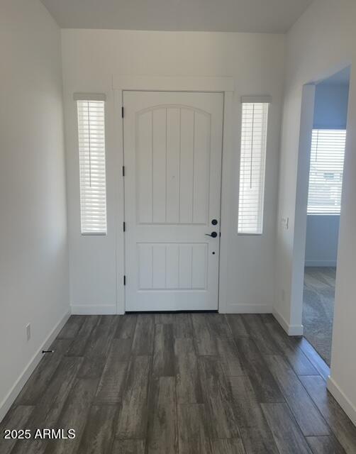 foyer entrance featuring dark wood-style floors and baseboards