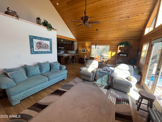 living room featuring wood-type flooring, ceiling fan, wooden ceiling, wooden walls, and high vaulted ceiling