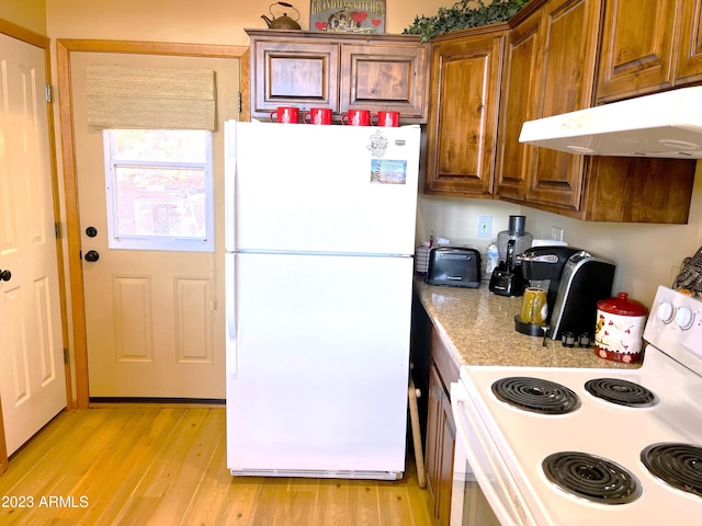 kitchen with light hardwood / wood-style flooring and white appliances