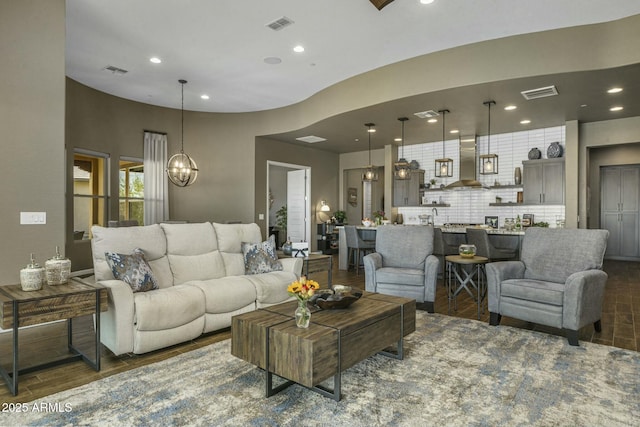 living room featuring dark hardwood / wood-style flooring and an inviting chandelier