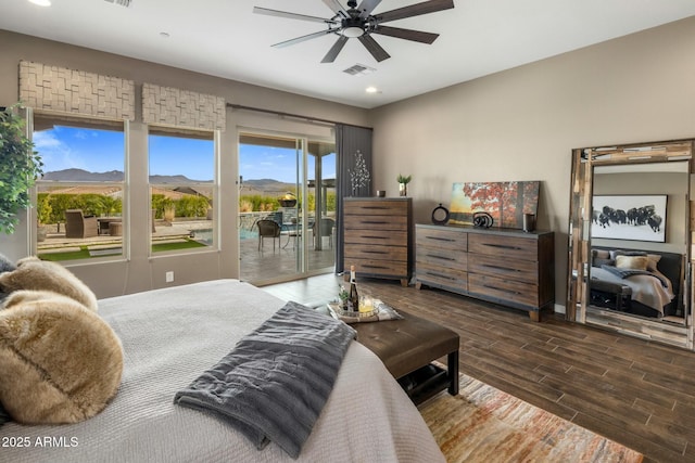 bedroom featuring ceiling fan, access to exterior, and a mountain view