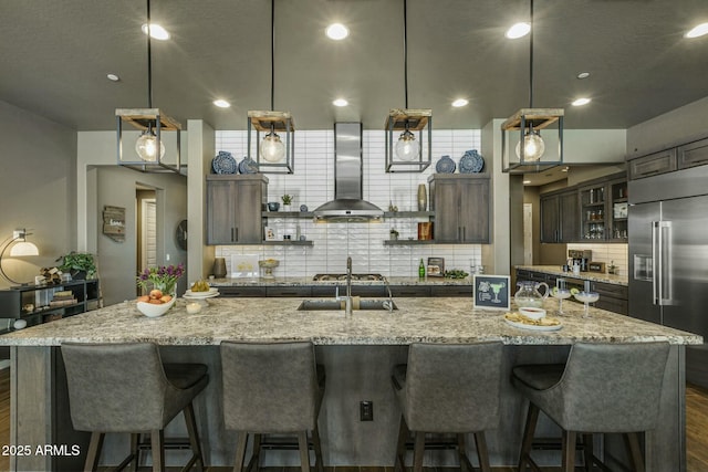 kitchen with ventilation hood, a large island, stainless steel appliances, and decorative light fixtures