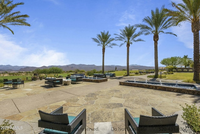 surrounding community with a patio area, a mountain view, and outdoor lounge area