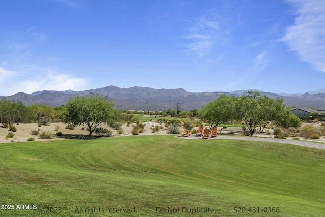 view of home's community with a mountain view and a yard