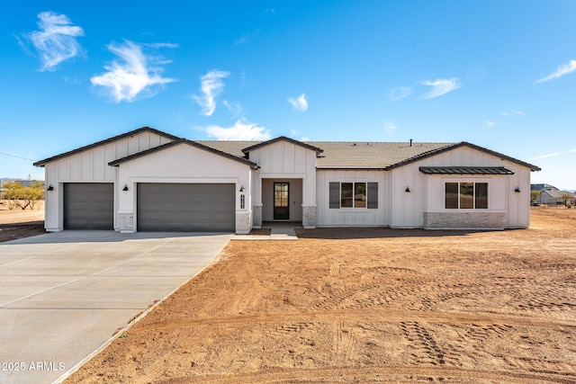 modern inspired farmhouse with a garage, driveway, and board and batten siding