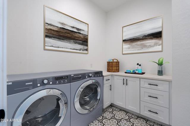 clothes washing area with light tile patterned floors, cabinets, and washing machine and dryer