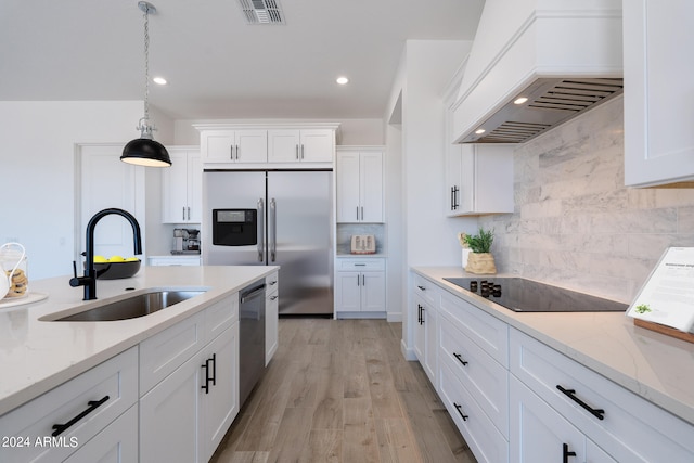 kitchen featuring custom range hood, light hardwood / wood-style floors, sink, decorative backsplash, and white cabinets