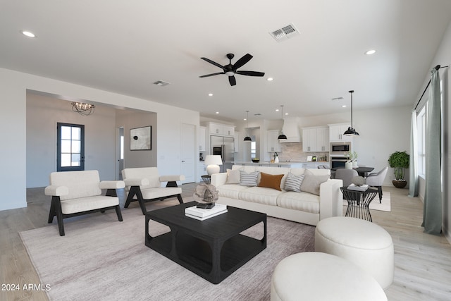 living room featuring ceiling fan and light hardwood / wood-style flooring