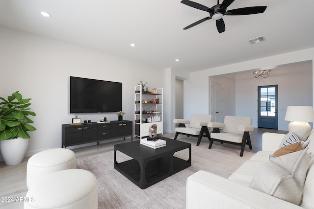 living room featuring light hardwood / wood-style flooring and ceiling fan