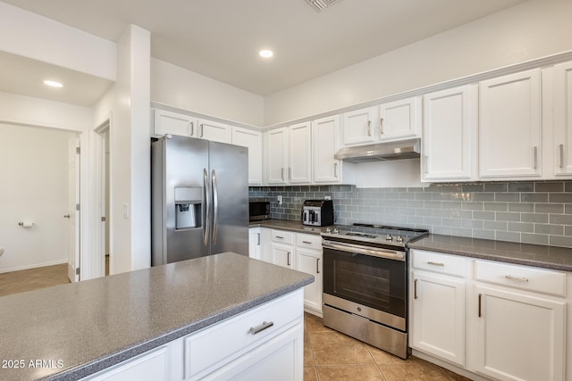 kitchen featuring decorative backsplash, white cabinetry, light tile patterned floors, and appliances with stainless steel finishes