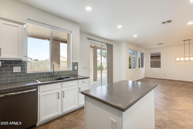 kitchen featuring white cabinets, tasteful backsplash, sink, decorative light fixtures, and dishwasher