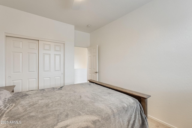 carpeted bedroom with ceiling fan and a closet