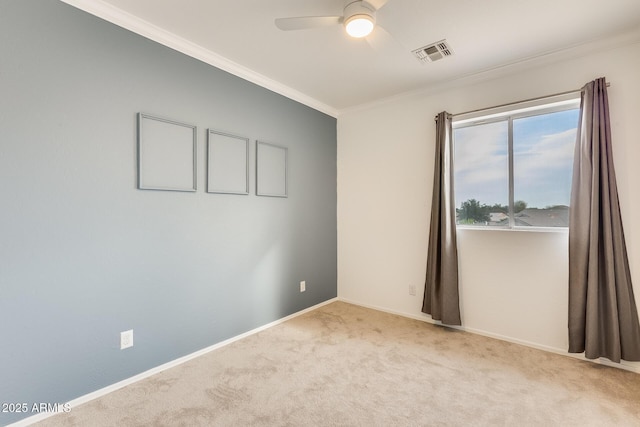 spare room featuring light colored carpet, ceiling fan, and ornamental molding