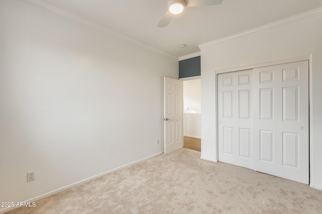 unfurnished bedroom featuring light carpet, a closet, crown molding, and ceiling fan