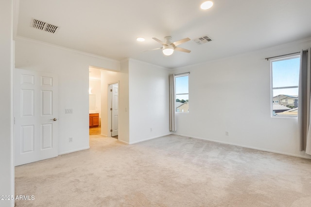 carpeted empty room with ceiling fan and crown molding