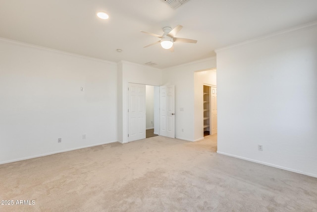 carpeted spare room with ceiling fan and ornamental molding