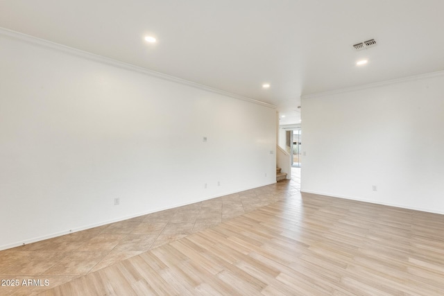 spare room featuring light tile patterned flooring and ornamental molding